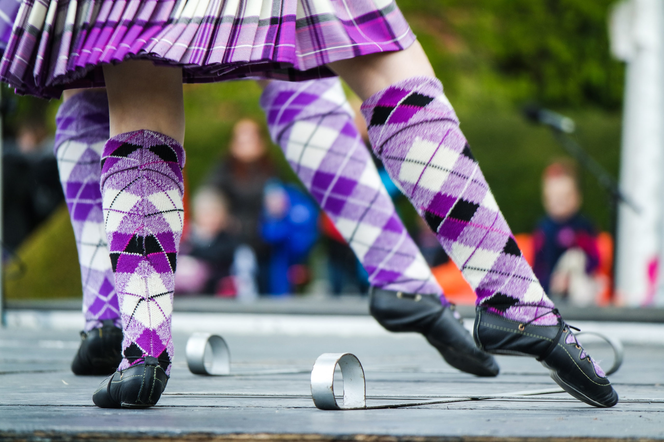 Legs of highland dancers in purple